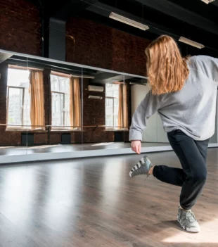 blonde-young-woman-dancing-against-mirror-dance-studio